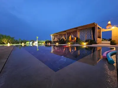 a swimming pool at night with a building at bled ghazal in Marrakech