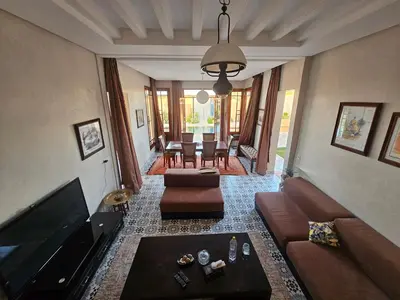 a living room with couches and a television and a table at bled ghazal in Marrakech