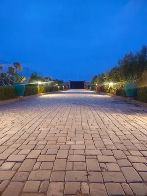 a cobblestone street at night with lights at bled ghazal in Marrakech
