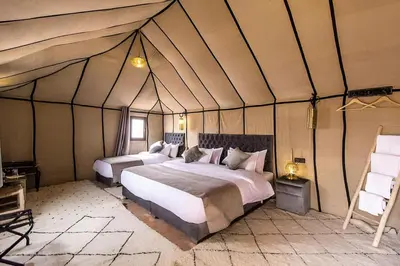 a bedroom with two beds in a tent at Layali Luxury Desert Camp in Merzouga