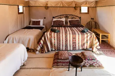 a bedroom with two beds in a tent at Luxury beldi camp in Merzouga