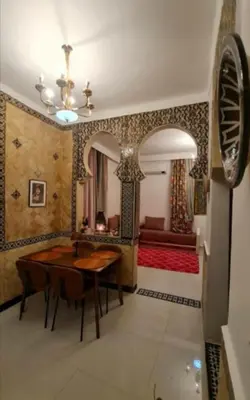 a dining room with a table and a bed at Dar House Fez in Fès