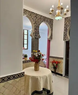 a room with a table with a vase of flowers on it at Dar House Fez in Fès