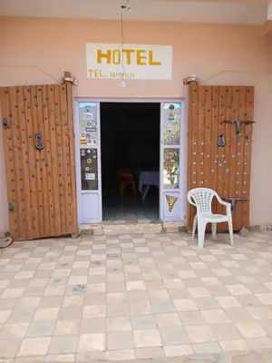a hotel entrance with a chair and a table at Gueste housse ait hani in Aït Hani