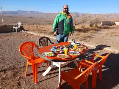 a man standing next to a table with food on it at Gueste housse ait hani in Aït Hani