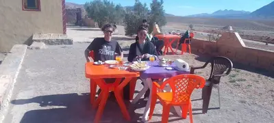 two women sitting at a table with food on it at Gueste housse ait hani in Aït Hani