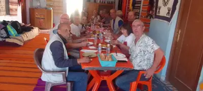 a group of people sitting at a table eating food at Gueste housse ait hani in Aït Hani