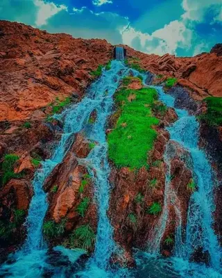 a waterfall on the side of a rocky mountain at Gueste housse ait hani in Aït Hani