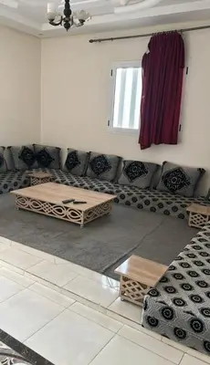 a living room with a couch and tables and a window at Casa de playa in Oulad Akkou