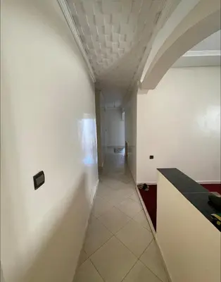 a hallway with a white wall and a ceiling at Casa de playa in Oulad Akkou