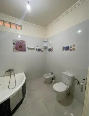 a white bathroom with a toilet and a sink at Casa de playa in Oulad Akkou