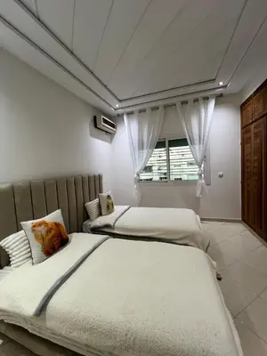 a bedroom with two beds and a window at Prestige Immo in Fès