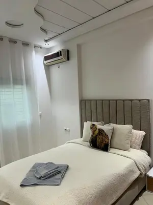 a cat sitting on a bed in a bedroom at Prestige Immo in Fès
