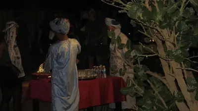a woman standing in front of a table with a woman standing behind it at SANDSTAR LUXURIOUS CAMP air-conditioned in Merzouga