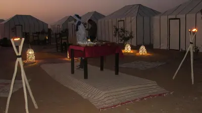 a group of tents with a table in front of it at SANDSTAR LUXURIOUS CAMP air-conditioned in Merzouga