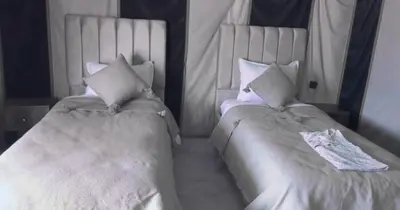 two beds sitting next to each other in a bedroom at SANDSTAR LUXURIOUS CAMP air-conditioned in Merzouga