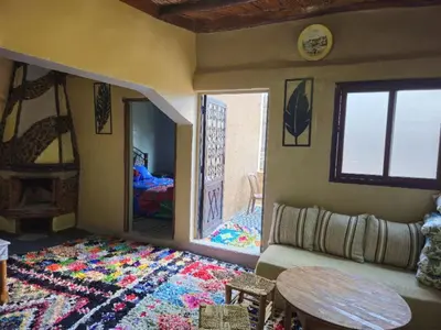 a living room with a couch and a table at Gite Soleil Private House in Tacheddirt