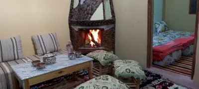 a living room with a fireplace and a mirror at Gite Soleil Private House in Tacheddirt
