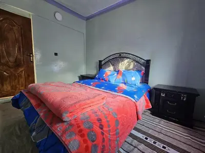 a bedroom with a bed and a wooden floor at Gite Soleil Private House in Tacheddirt