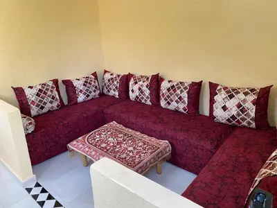 a living room with a red couch with pillows at siti fadma ourika Marrakech in Aghbalou