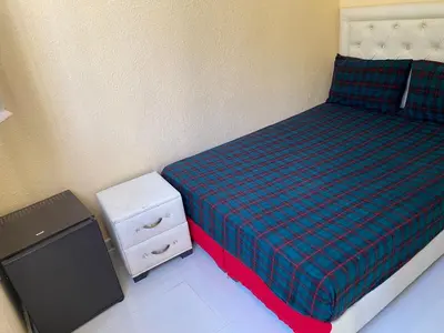 a small bedroom with a bed and a night stand at siti fadma ourika Marrakech in Aghbalou