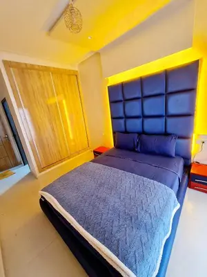 a bedroom with a large bed with a blue headboard at Premium Apartment Fes - Route Ain Chkef in Fès