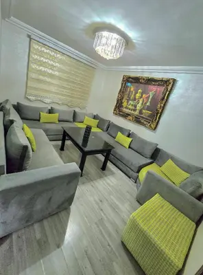 a living room with a gray couch and yellow pillows at Premium Apartment Fes - Route Ain Chkef in Fès