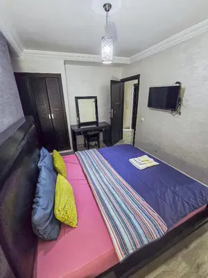 a bedroom with a large bed with a colorful blanket at Premium Apartment Fes - Route Ain Chkef in Fès