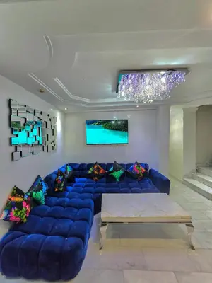 a living room with a blue couch and a tv at Premium Apartment Fes - Route Ain Chkef in Fès