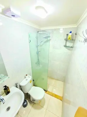 a bathroom with a toilet and a glass shower at Premium Apartment Fes - Route Ain Chkef in Fès
