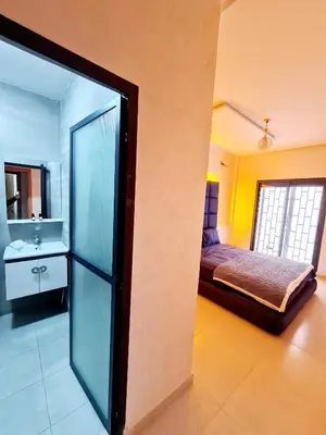 a room with a bed and a bathroom with a mirror at Premium Apartment Fes - Route Ain Chkef in Fès