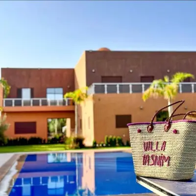 a basket sitting on a table in front of a pool at Tasnim VILLA in Marrakech