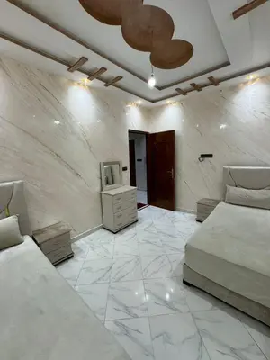 a bedroom with two beds and a tv on a wall at house Perfect well equipped in Midelt
