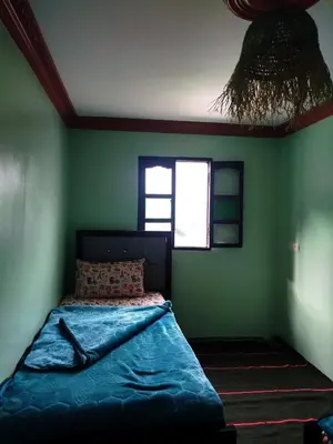 a bedroom with a bed in a green wall at Gîte Assonfo Tachdirt in Tacheddirt