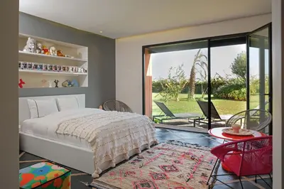 a bedroom with a bed and a table and chairs at Villa Shelter in El Bougaria