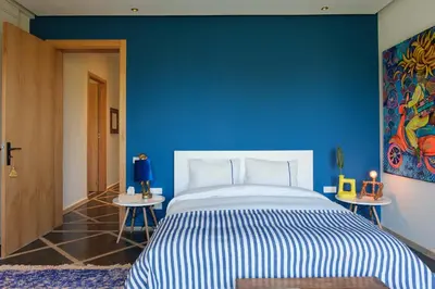 a blue bedroom with a bed and a blue wall at Villa Shelter in El Bougaria