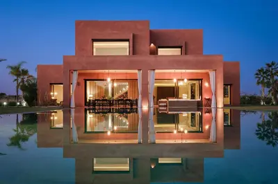 a building with its reflection in a pool of water at Villa Shelter in El Bougaria
