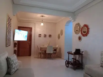 a living room with a table and a television at Appartement confortable in Fès