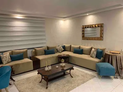 a living room with a large couch and a table at Appartement luxueuse au centre ville de Fès in Fès