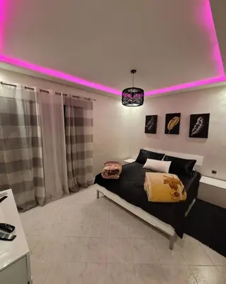 a bedroom with a bed with a pink lighting at Appartement luxueuse au centre ville de Fès in Fès
