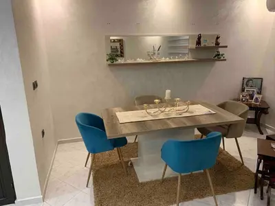a dining room with a wooden table and blue chairs at Appartement luxueuse au centre ville de Fès in Fès