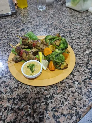 a plate of food with meat and vegetables on a counter at Fassia in Fès