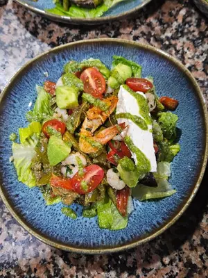 a blue plate of salad with tomatoes and other vegetables at Fassia in Fès