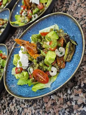 a blue plate with a salad on a table at Fassia in Fès