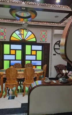 a room with a table and chairs and a stained glass window at Fassia in Fès