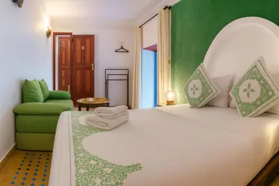 a bedroom with a white bed and a green wall at Riad rayhane fez in Fès