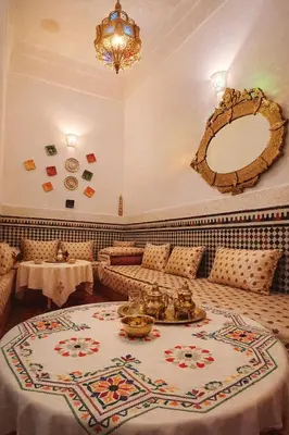 a living room with a couch and a table and a mirror at Riad rayhane fez in Fès