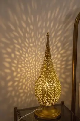 a gold lamp sitting on a glass table in front of a wall at Riad rayhane fez in Fès
