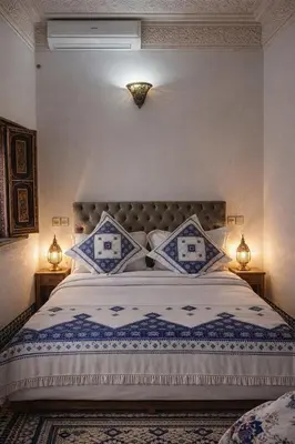 a bedroom with a large bed with blue and white sheets at Riad rayhane fez in Fès