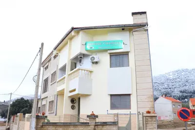 a building with a sign on the side of it at Gîte - Auberge PYRAMIDES Bab Boudir in Bab Boudir
